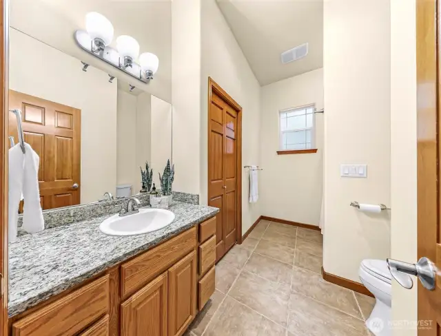Guest bathroom with large storage closet and bathtub/shower.