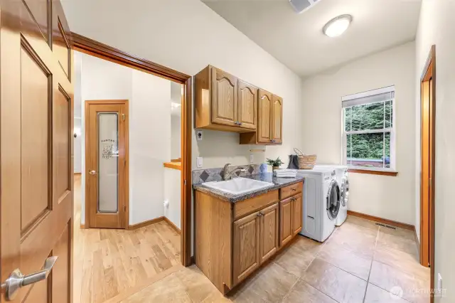 This laundry room is coming in from the garage and there is a toilet room to the right.