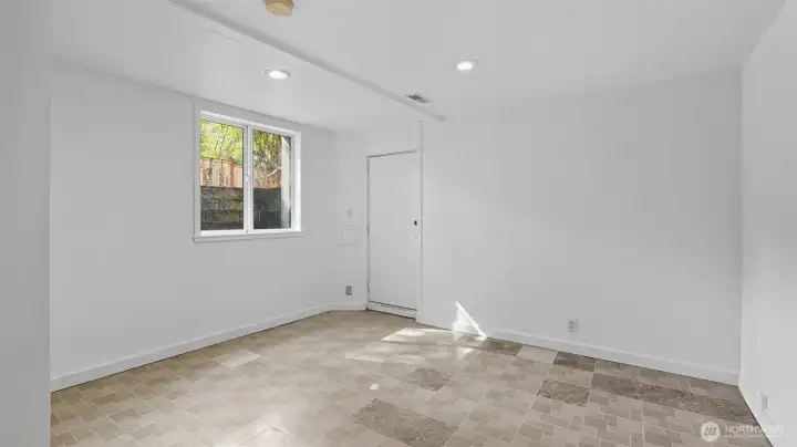 2nd of two full-height bedrooms downstairs. Also has the proper window well for egress. Door in this picture leads to backyard.