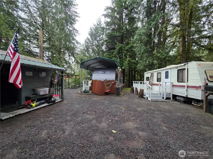 RVs both have porches and the outbuilding shown is a small shop.