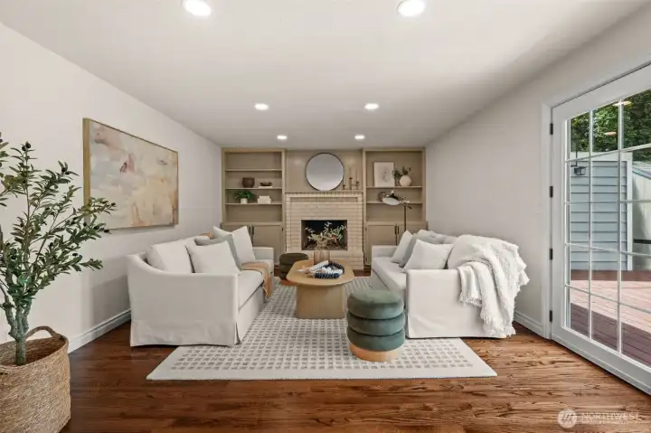 Spacious living room is centered around a fireplace and framed by built-in shelving for display and storage.