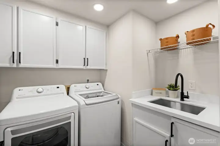 Well-equipped laundry space provides extra storage and a utility sink to support daily household tasks.