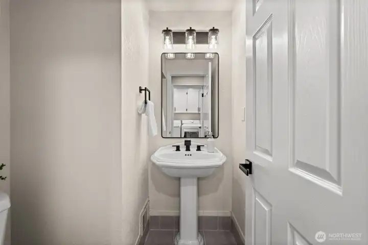 Convenient main-level powder room features updated fixtures and a pedestal sink.