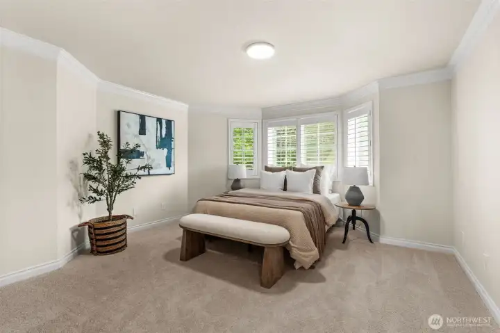 The primary bedroom features expansive wall space, neutral finishes, and a bright window complete with shutters offering privacy and perfect natural light control.