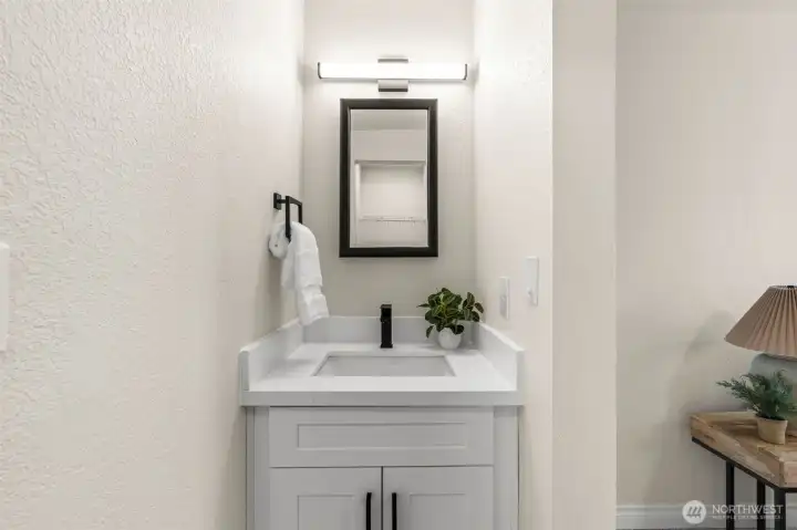 Private vanity area features updated cabinetry, quartz counters, and modern fixtures.