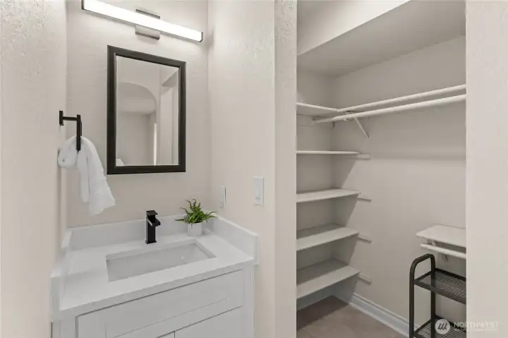 Walk-in closet features generous storage options and an adjacent vanity for added functionality.