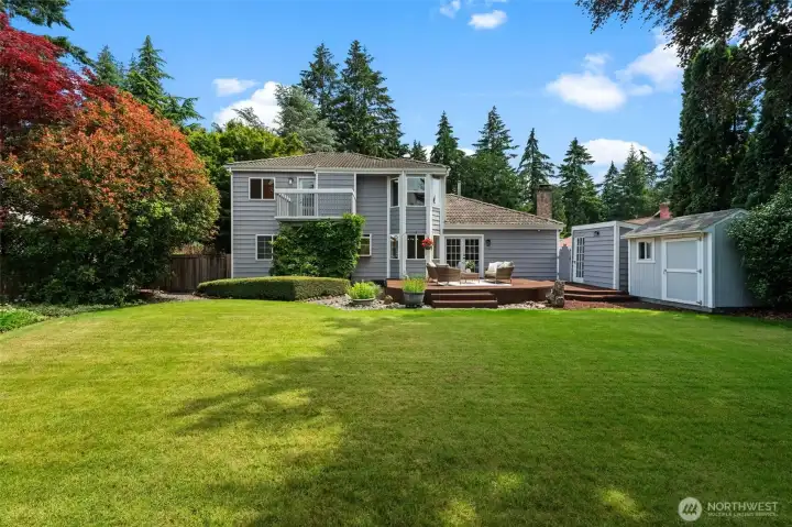 Expansive backyard features a large lawn, mature landscaping, and generous outdoor living space.