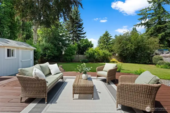 Outdoor seating area is positioned to enjoy views of the level lawn and surrounding greenery.