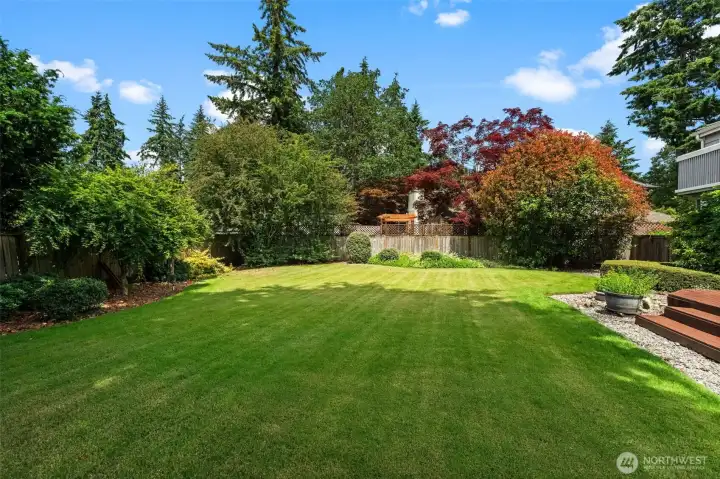 Spacious yard showcases established plantings, open green space, and a private setting.