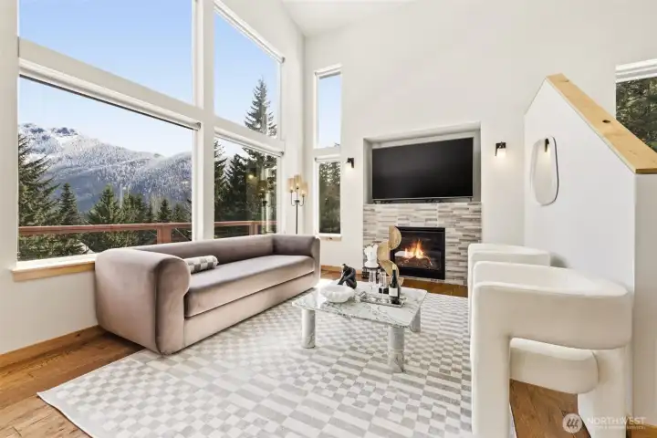 Floor-to-ceiling windows in the living room anchored with a gas fireplace