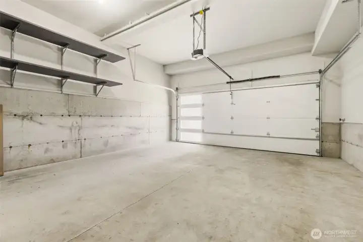 Two car garage with shelving and extra space for a work bench