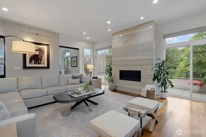 The living room features floor-to-ceiling Italian  silver travertine marble surrounding the welcoming fireplace.