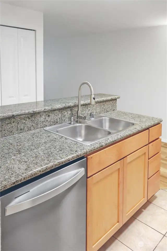 Granite counters, a stainless steel dishwasher, a double sink, a faucet with a retractable nozzle, and plenty of storage space . . . what more could you ask for? An eat-in bar? This home has that too!