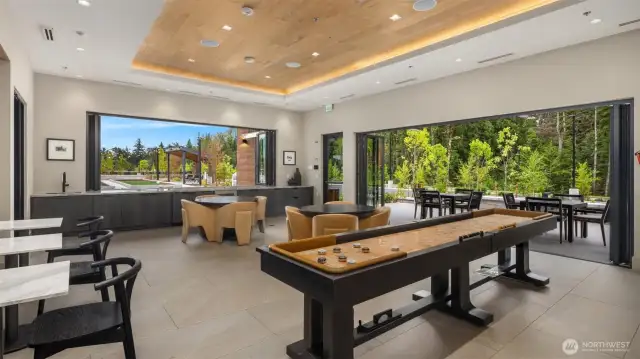 Clubhouse lounge with large screen televisions and shuffleboard