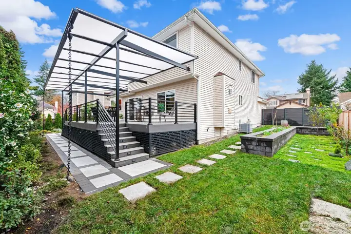 Raised vegetable bed and 5 varieties of fruit trees make this back yard a gardener's dream.