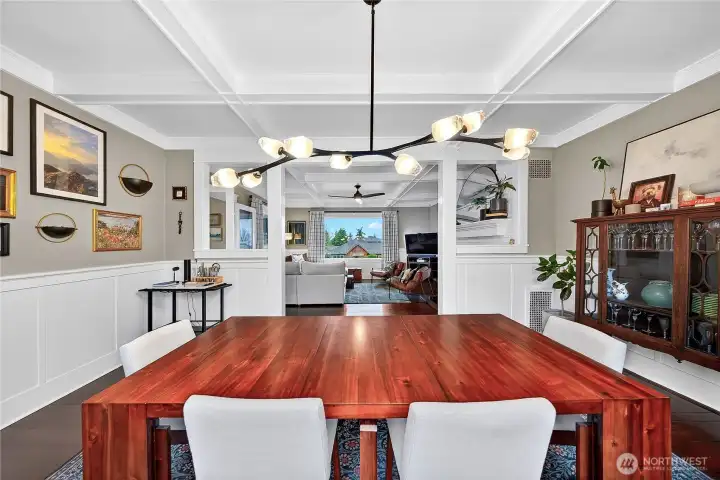 Dining room with picture frame molding and box and beam ceiling details.