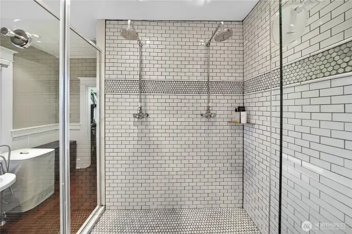 beautiful tile shower with glass surround.