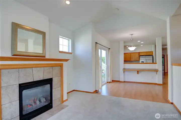 Living room has vaulted ceilings and cozy gas fireplace.