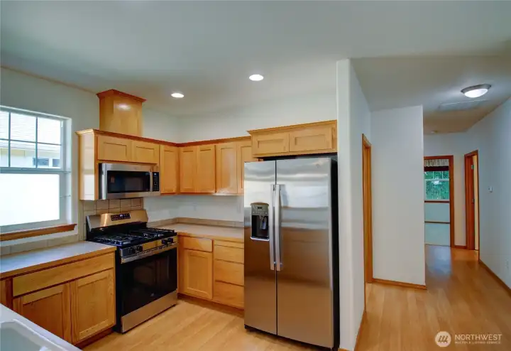 Oak wood cabinets have been refinished and are in pristine condition.
