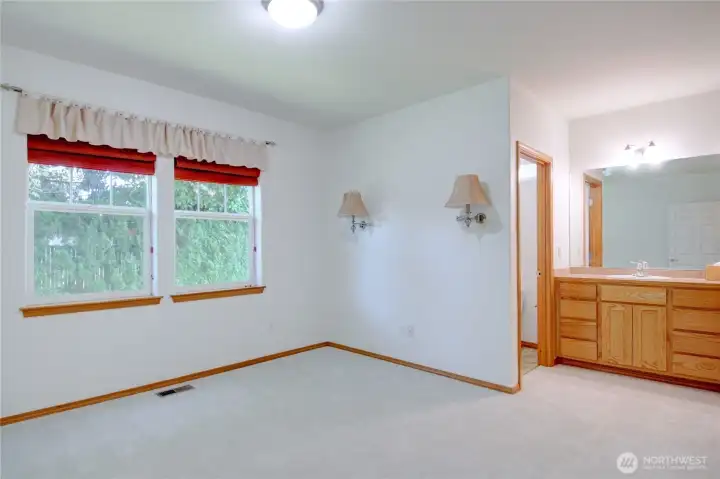 Large primary bedroom with new carpet and en-suite vanity and bathroom.