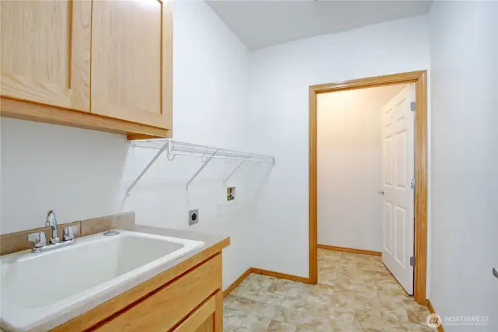 Laundry room with broom closet is centrally located near kitchen, 3rd bed/den and garage.