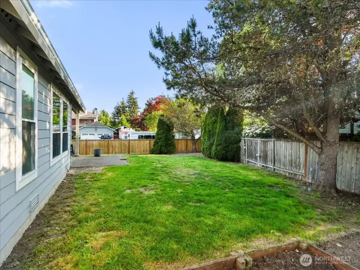 Spacious backyard with room for entertaining, pets, and raised bed gardening.