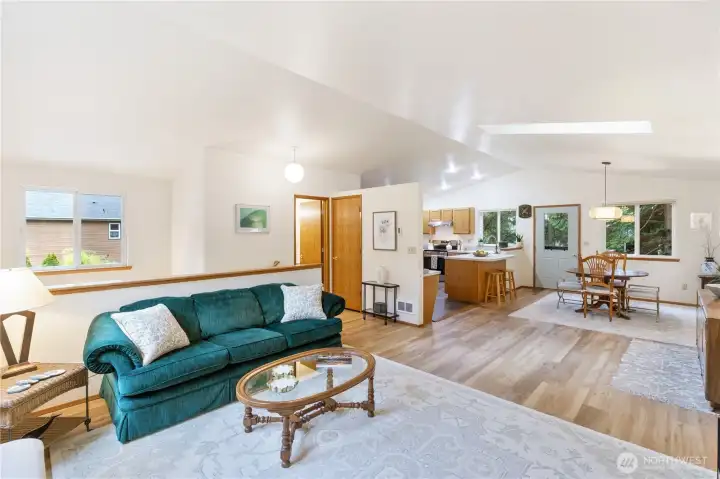 Open floor plan to the dinning room and kitchen, with the half bath on the left.