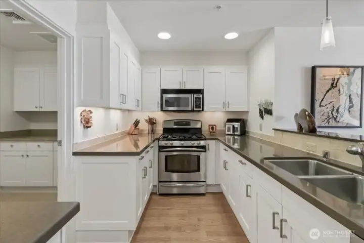 Spacious kitchen, with ample cabinets and sleek, hard surface countertops.