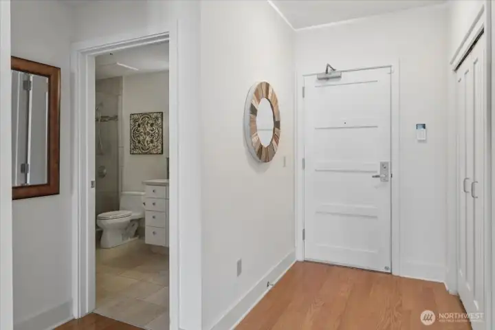 Front door entrance and hallway to primary bathroom.