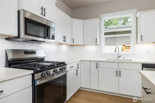There's a window over the sink and a gas range with microhood!
