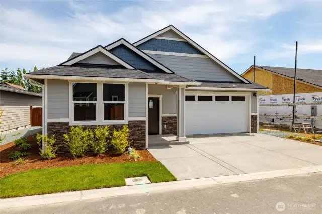 There is upgraded concrete siding and stone on the facade of this home.