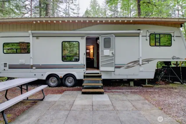 Trailer with steps and metal roof with overhang