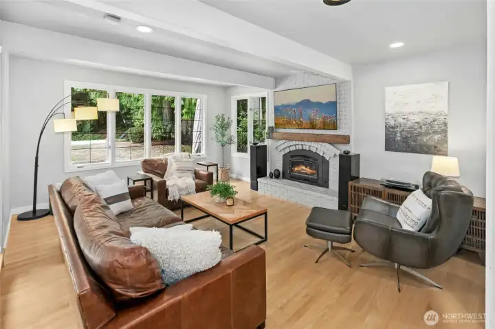 Cozy living room with wood burning fireplace looking out to the private yard.