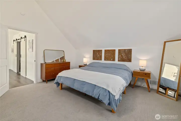 Upstairs primary suite with vaulted ceilings.