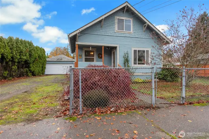 Front of home with large detached garage in back.