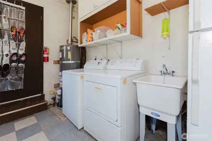 Laundry room off of kitchen with wash bin, storage and extra fridge