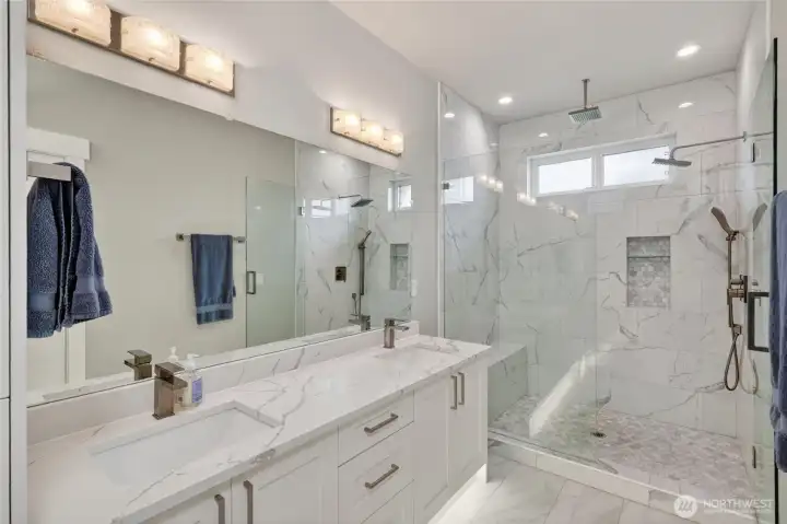 Primary bedroom's ensuite, with beautiful counters, walk-in shower and under-cabinet lighting.