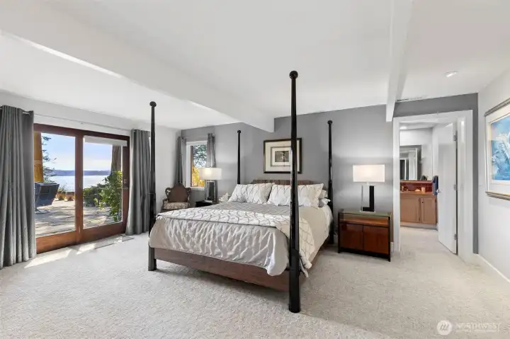 Spacious primary bedroom with door out to the waterside patio. Spacious primary bedroom with door out to the waterside patio.