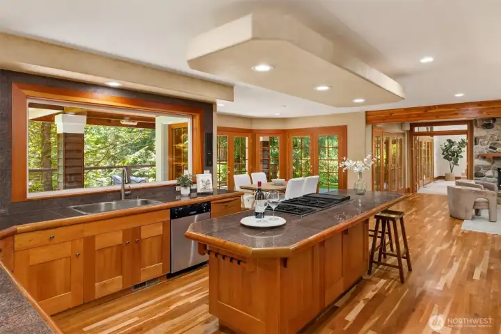 The grand chef's kitchen, well appointed with cherry cabinetry, granite counters and garden view across the expansive deck.