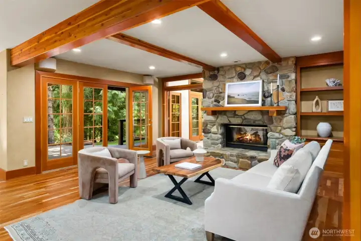 The family room with a river rock fireplace, indoor/outdoor living and custom built-ins.