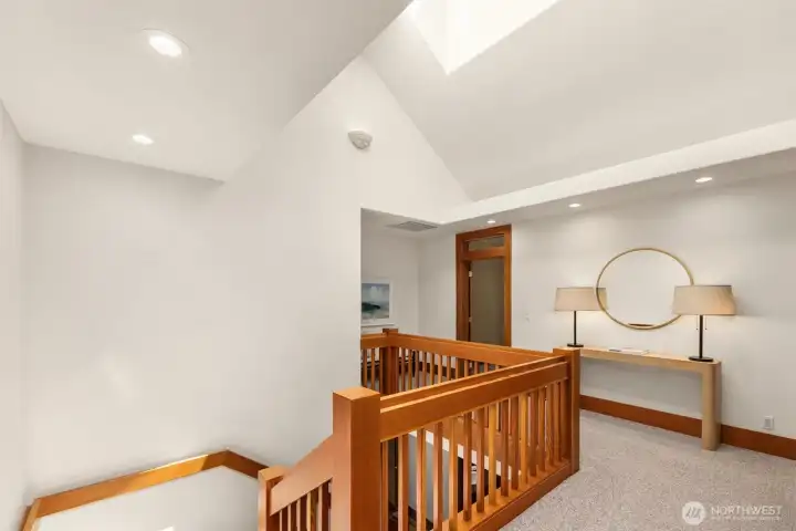 The second floor landing with skylight and vaulted ceiling. Straight on is the primary suite.