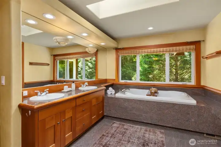 The 5-piece primary bath with deep soaking tub and skylight.