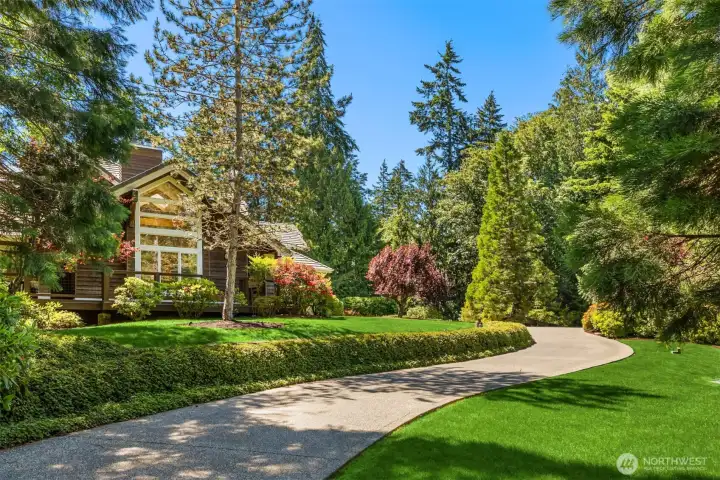 Paved winding driveway uphill to the home.