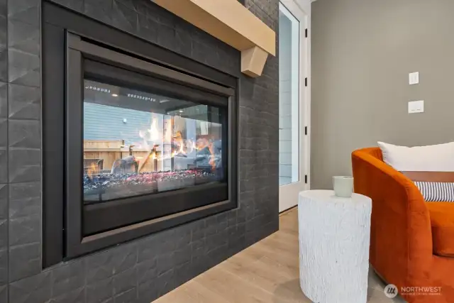 Dramatic double-sided fireplace to be enjoyed inside and outside.