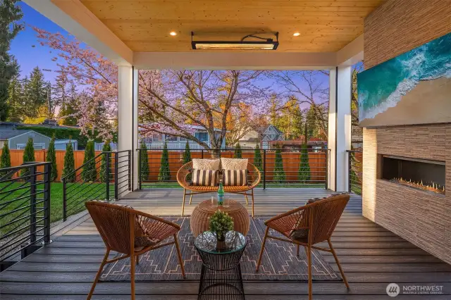 Outdoor patio with TV, gas fireplace, speakers, and heaters