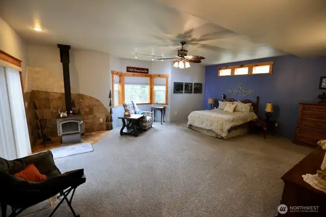 Very large master bedroom with custom tile work around the wood stove.