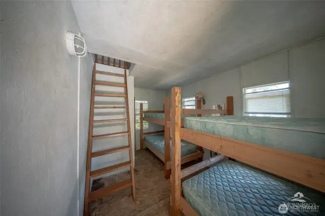 Interior of guest cabin with extra sleeping quarters on both levels. Power and small sink.