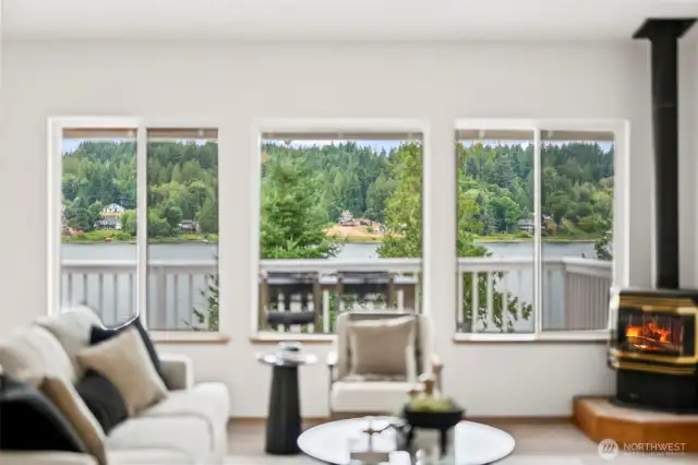 Large picture windows frame tranquil water and wooded views