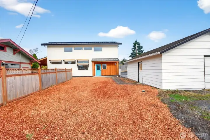The side yard looking back towards the house and garage/shop.