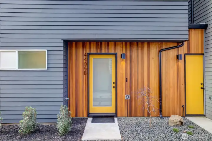 Vertical cedar siding defines the exterior with warmth and texture, setting the architectural tone.